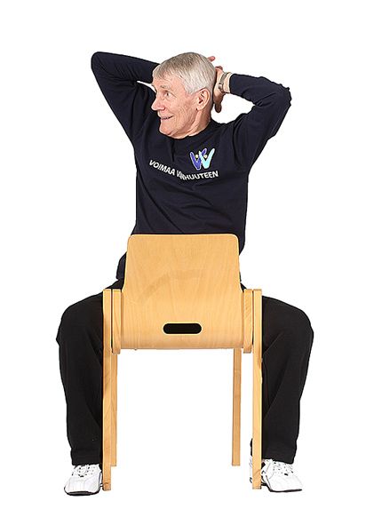 Jumppaaja istuu ryhdikkäästi tuolilla rintamasuunta kohti selkänojaa ja on kiertänyt ylävartaloa oikealle katseen seuratessa mukana.