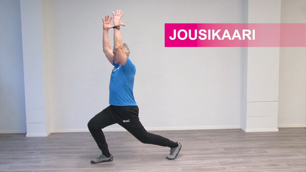 Jumppaaja ottanut toisella jalalla pitkän askeleen eteen ja kurottaa käsiä ylöspäin lantiosta hieman eteenpäin joustaen.