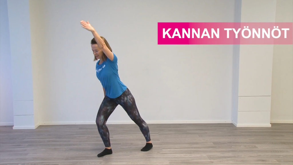 Jumppaaja on vienyt seisten toisen jalan taakse ja venyttää sen pohjetta. Toinen käsi on ylhäällä vartalon jatkona.